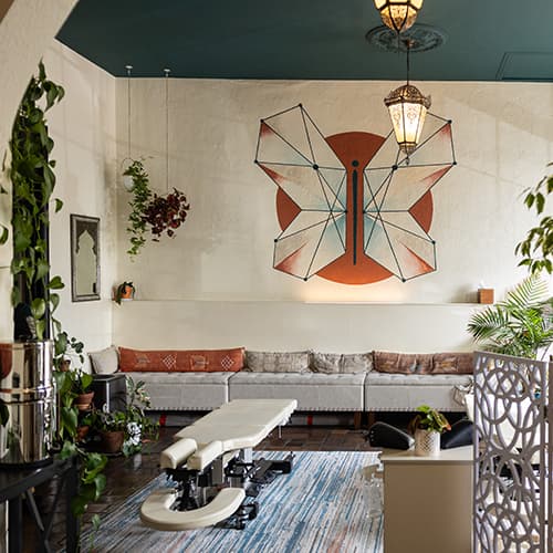 Anam Cara Chiropractic — treatment room with signature butterfly artwork and warm earth-tone decor